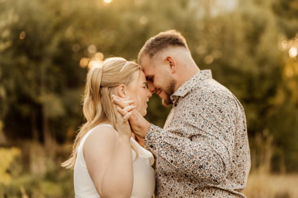 After Wedding Shooting Braut mit Brautkleid auf einer grünen Wiese im Sonnenuntergang