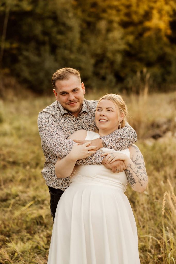 After Wedding Shooting Braut mit Brautkleid auf einer grünen Wiese im Sonnenuntergang