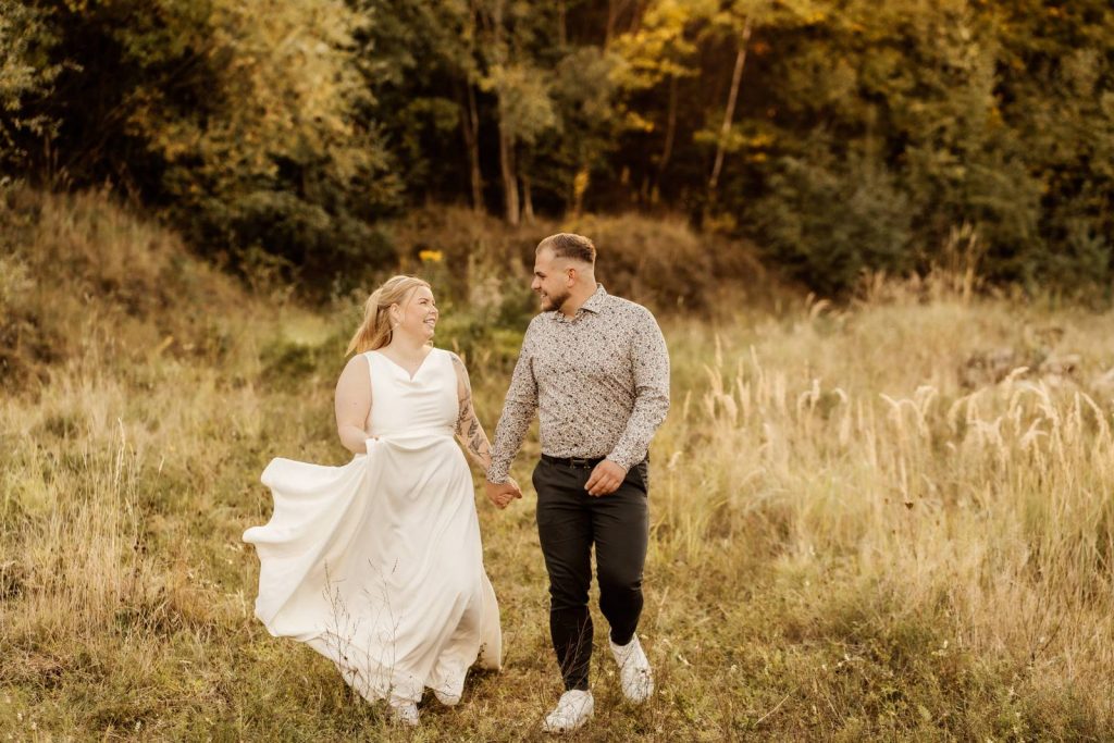 After Wedding Shooting Braut mit Brautkleid auf einer grünen Wiese im Sonnenuntergang