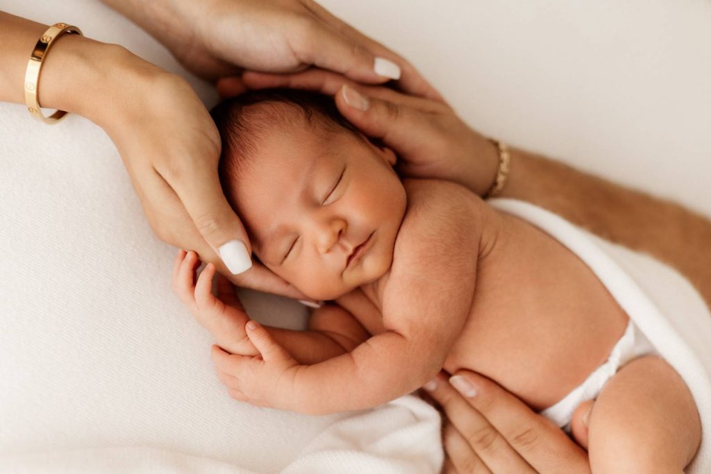 Baby gehalten von Mama und Papa beim Babyshooting