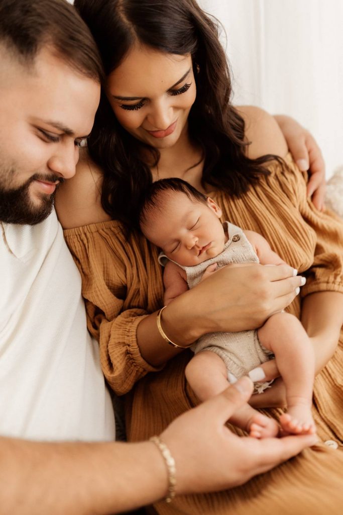 Baby gehalten von Mama und Papa beim Babyshooting