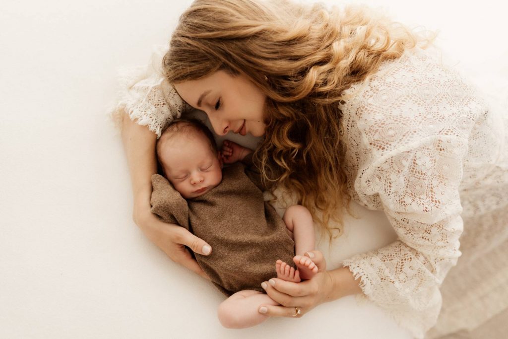 Baby gehalten von Mama beim Babyshooting