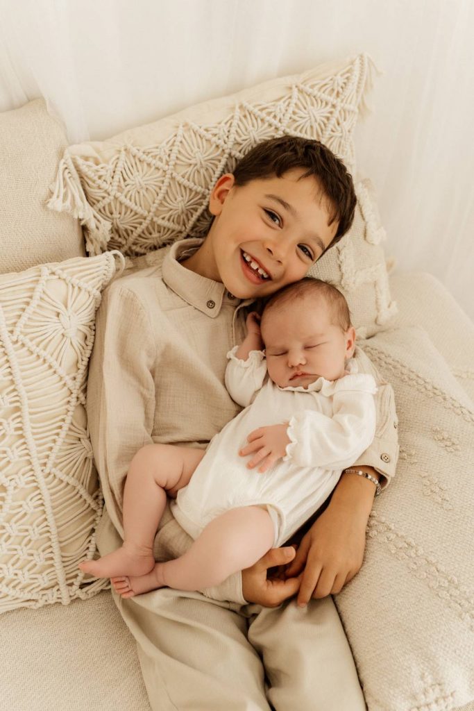 Baby gehalten von Geschwisterkind beim Babyshooting