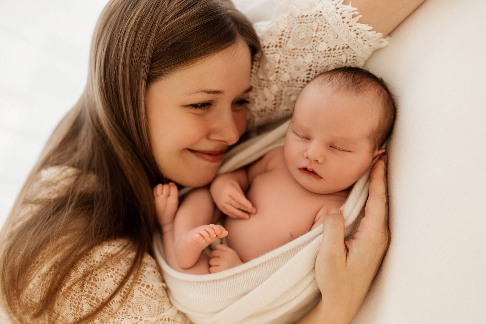 Baby gehalten von Mama beim Babyshooting