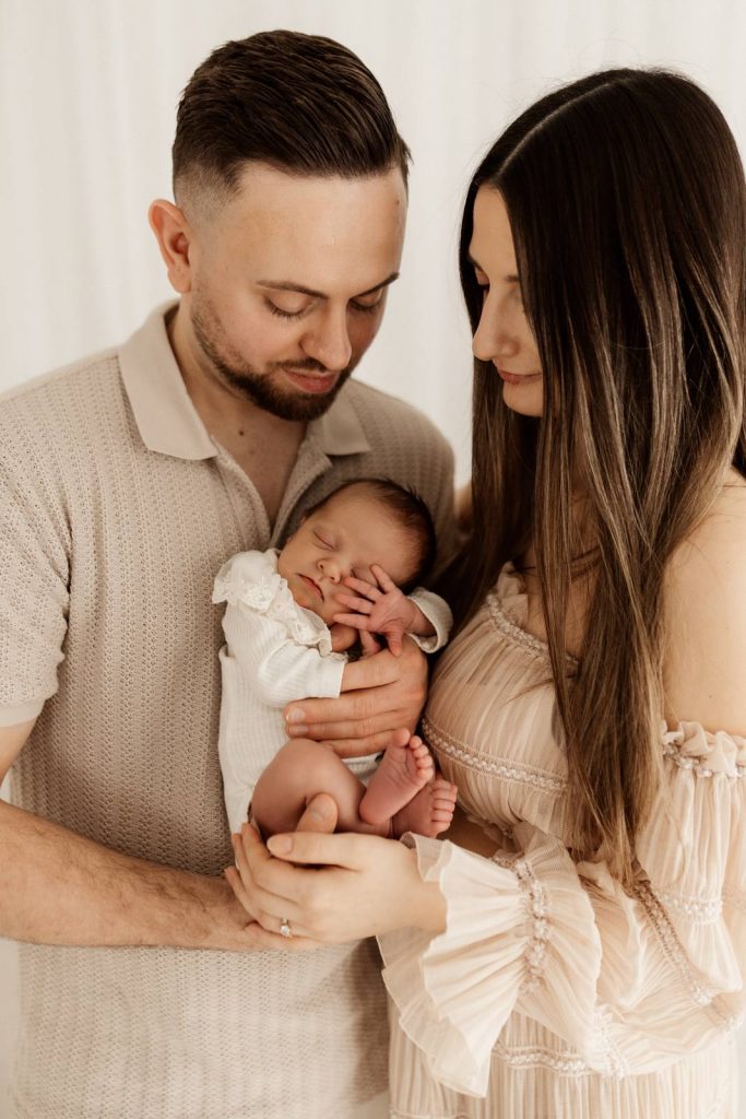 Baby gehalten von Mama und Papa beim Babyshooting
