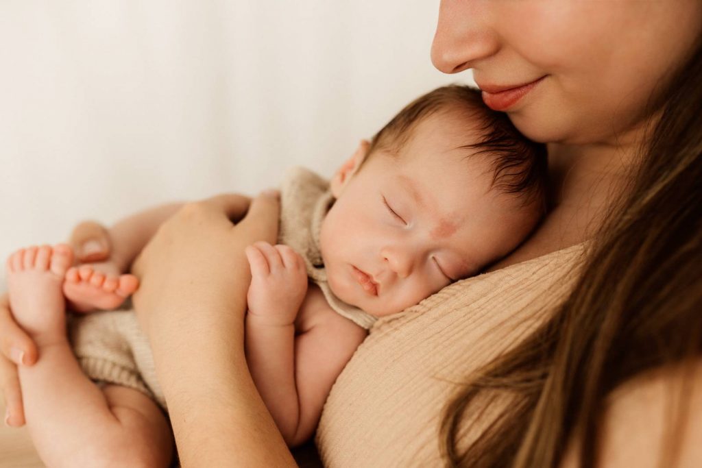 Baby gehalten von Mama beim Babyshooting