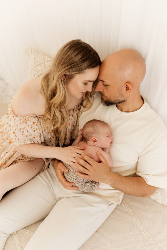 Baby gehalten von Mama und Papa beim Babyshooting