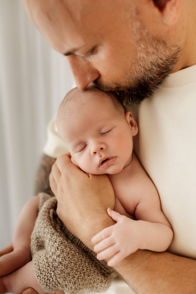 Baby gehalten von Papa beim Babyshooting