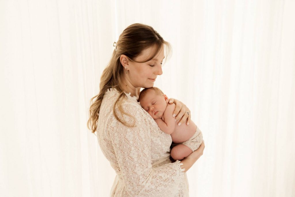 Baby gehalten von Mama beim Babyshooting