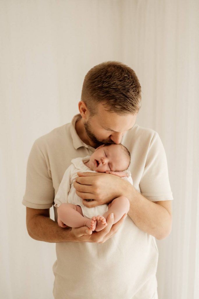 Baby gehalten von Papa beim Babyshooting