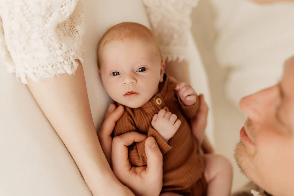 Baby gehalten von Mama und Papa beim Babyshooting